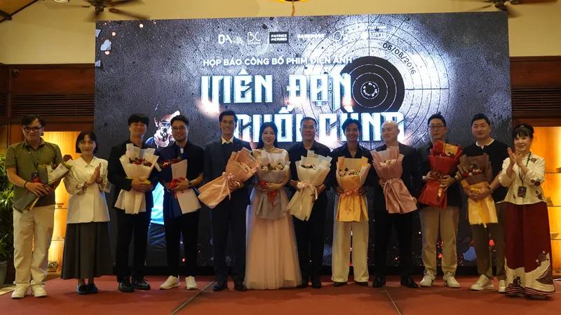 Bà Lý Phương Dung, Phó Chủ tịch Hiệp hội xúc tiến phát triển điện ảnh Việt Nam tặng hoa diễn viên, nhà sản xuất và xạ thủ Hoàng Xuân Vinh. Ảnh: XUÂN QUỲNH