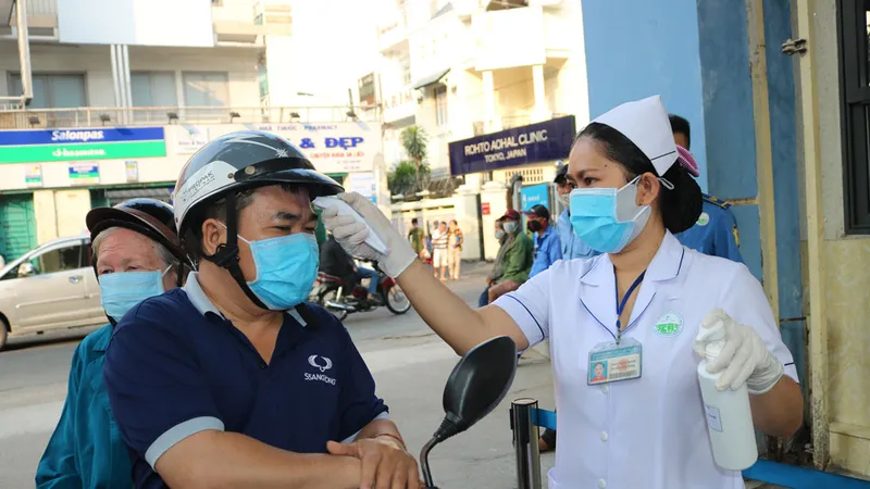 Người bệnh vào Bệnh viện Da liễu TPHCM phải bắt buộc đeo khẩu trang và được kiểm tra thân nhiệt, khai báo y tế ngay từ cổng. Ảnh: MINH NAM