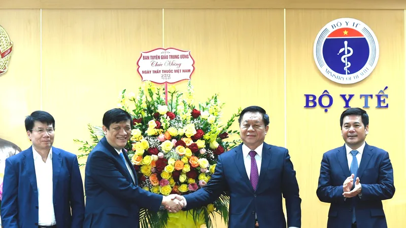 Thượng tướng Nguyễn Trọng Nghĩa, Bí thư Trung ương Đảng, Trưởng ban Tuyên giáo Trung ương tặng hoa cho Bộ trưởng Bộ Y tế Nguyễn Thanh Long. Ảnh: VGP