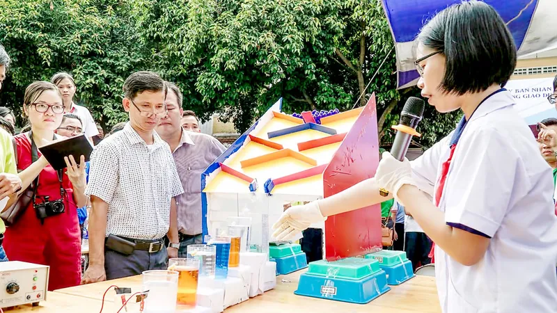 Học sinh Trường THCS Đồng Khởi giới thiệu thí nghiệm phản ứng hóa học theo dạng domino. Ảnh: HOÀNG HÙNG