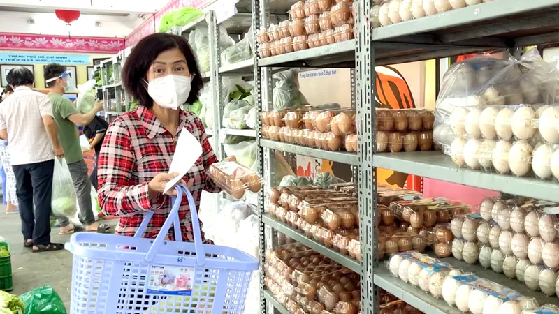 Cán bộ phường đến cửa hàng không lợi nhuận của quận 5 để mua đồ cho người dân. Ảnh: HOÀNG HÙNG