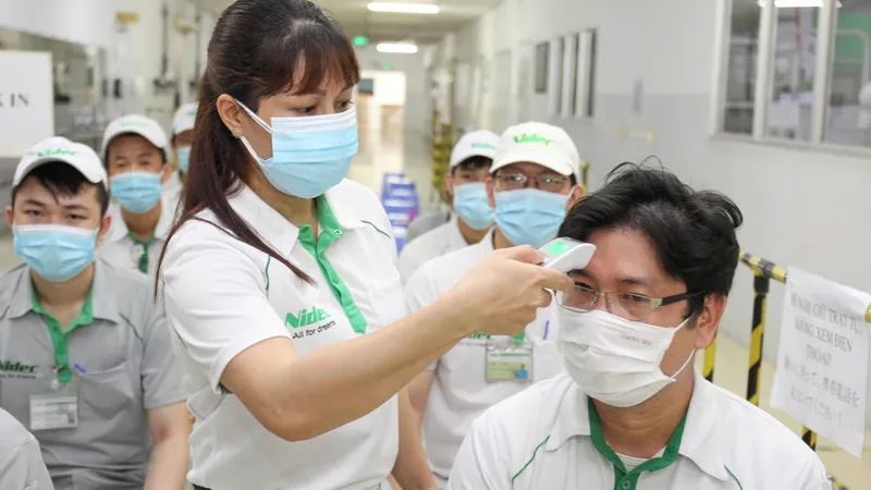 Đo thân nhiệt trước khi tiêm vaccine Covid-19 cho nhân viên Công ty Nidec (Khu công nghệ cao TPHCM). Ảnh: HOÀNG HÙNG