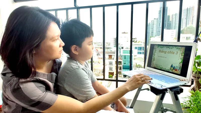 Mẹ kèm con học online tại nhà. Ảnh: DŨNG PHƯƠNG