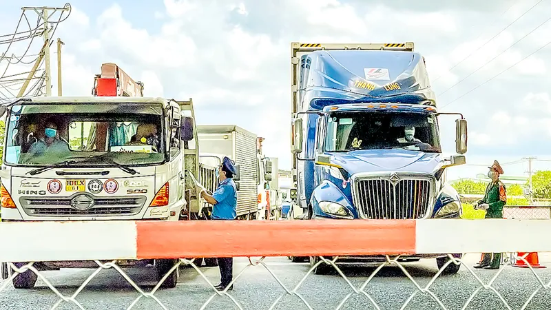 Lực lượng chức năng kiểm tra giấy thông hành tại trạm Ngã 3 Làng QL1A - Bình Chánh, TPHCM. Ảnh: HOÀNG HÙNG