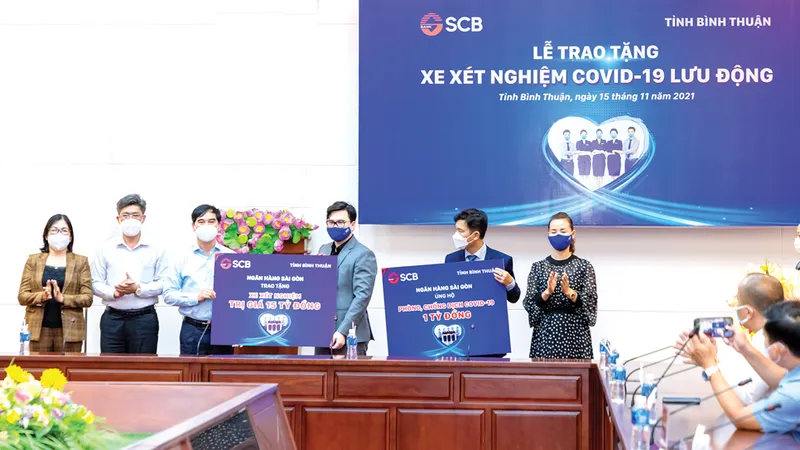 Ông Trương Khánh Hoàng - Q.TGĐ SCB trao bảng tượng trưng xe xét nghiệm Covid-19 lưu động có giá trị 15 tỷ đồng và 01 tỷ đồng cho Quỹ cứu trợ của UBMTTQ Việt Nam tỉnh Bình Thuận