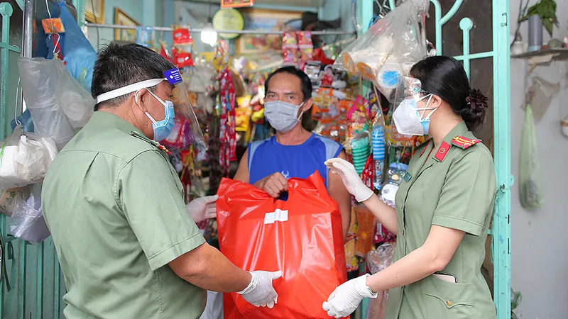 Công an quận 4, TPHCM tặng quà cho người nghèo bị ảnh hưởng bởi dịch Covid-19. Ảnh: DŨNG PHƯƠNG