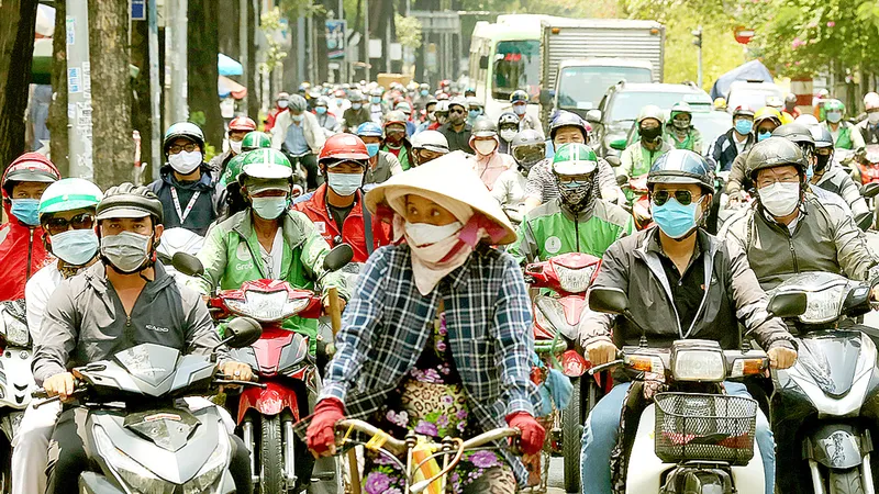 Người dân ở TPHCM đeo khẩu trang khi tham gia giao thông để phòng chống dịch Covid-19 và có cái tết an toàn. Ảnh: DŨNG PHƯƠNG