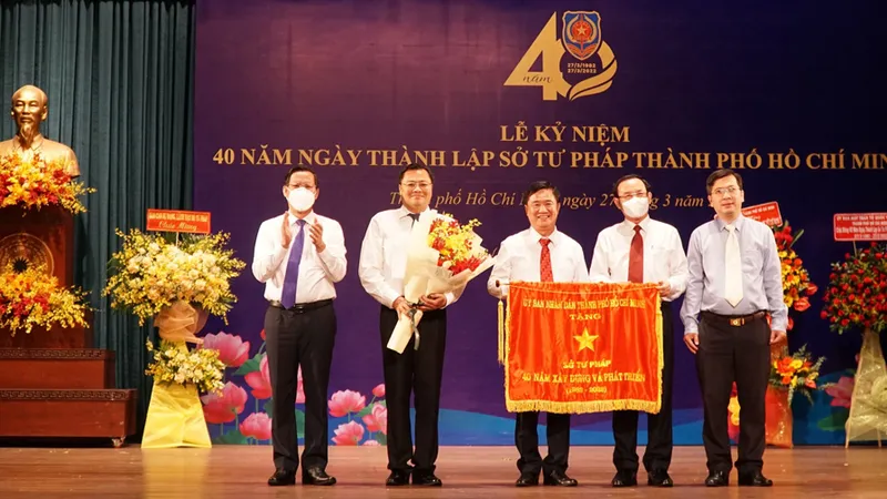 Bí thư Thành ủy TPHCM Nguyễn Văn Nên, Chủ tịch UBND TPHCM Phan Văn Mãi trao cờ truyền thống của UBND TPHCM cho Sở Tư pháp. Ảnh: MAI HOA
