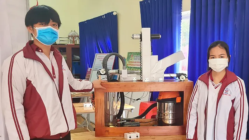 Hà và An bên máy hút dịch chanh dây bán tự động do 2 em thiết kế