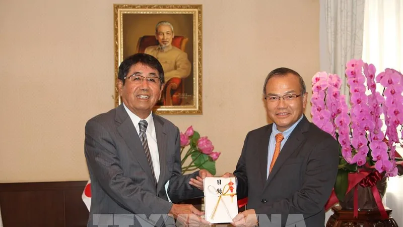 Đại diện doanh nghiệp Nhật Bản trao tượng trưng tiền hỗ trợ cộng đồng người Việt ở Nhật Bản cho Đại sứ Vũ Hồng Nam trong đợt dịch Covid-19 năm 2021. Ảnh: TTXVN
