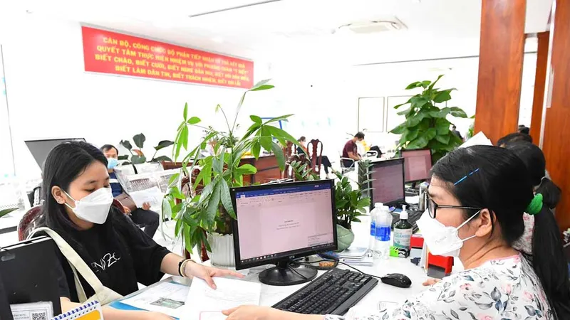 Cán bộ, công chức UBND huyện Bình Chánh (TPHCM) giải quyết hồ sơ cho người dân. Ảnh: VIỆT DŨNG