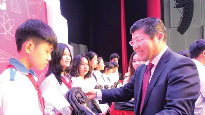 Ông Tsutomu Nara - Tổng Giám đốc công ty Ajinomoto Việt Nam trao học bổng và cặp sách cho học sinh
