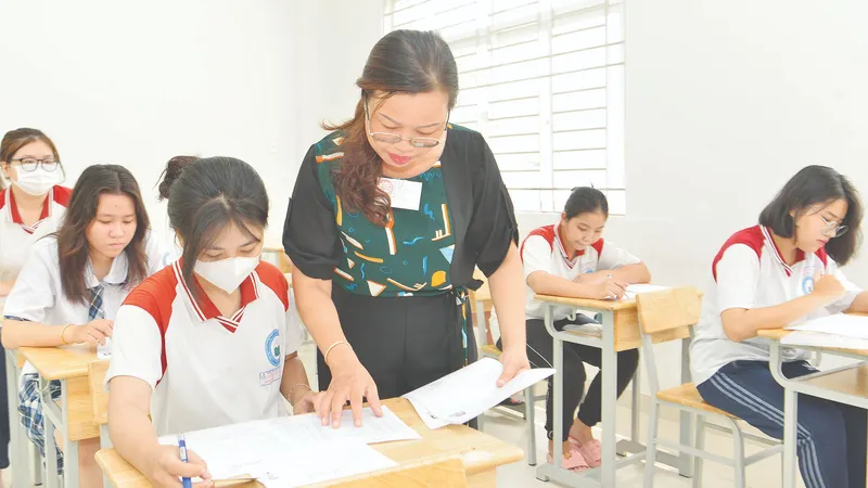 Giám thị tại điểm thi Trường THPT Lương Văn Can, quận 8 (TPHCM) kiểm tra thông tin trên phiếu báo danh thí sinh. Ảnh: CAO THĂNG