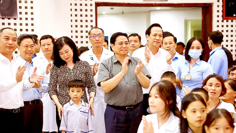 Thủ tướng Phạm Minh Chính và lãnh đạo các bộ, ngành thăm bệnh nhi đang điều trị tại Viện Huyết học và Truyền máu Trung ương. Ảnh: TTXVN
