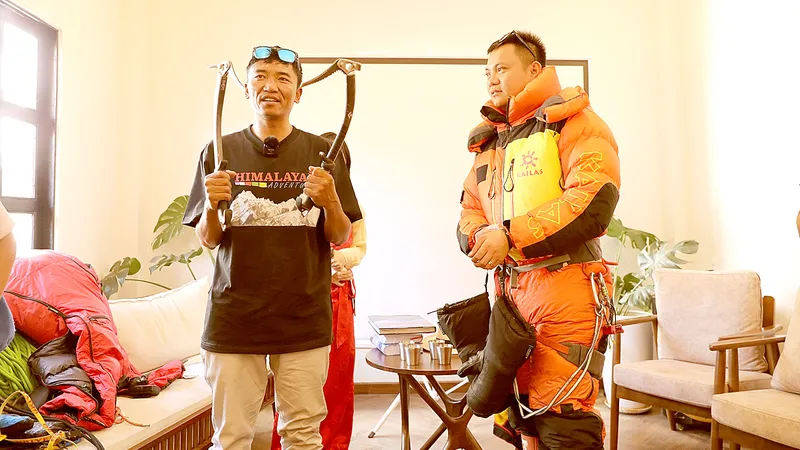 Anh Temba Bhote (bên trái) - người 10 lần chinh phục đỉnh Everest hướng dẫn cách mặc trang phục chuyên dùng khi leo núi tuyết cho bạn trẻ tham dự buổi giao lưu