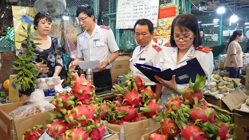 Thanh tra Ban Quản lý An toàn thực phẩm TPHCM kiểm tra một hộ kinh doanh trái cây tại chợ đầu mối nông sản Thủ Đức. Ảnh: HOÀNG HÙNG