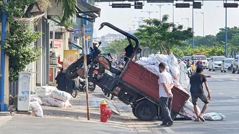 Xe ba bánh bị đổ do chở hàng cồng kềnh