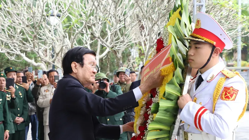 Nguyên Chủ tịch nước Trương Tấn Sang chỉnh vòng hoa trước khi dâng lên trước Tượng đài Tổ quốc ghi công tại Nghĩa trang Liệt sỹ quốc gia Vị Xuyên. Ảnh: VĂN NGHỊ