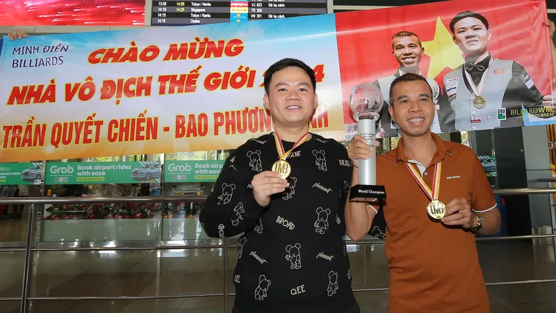 Phương Vinh và Quyết Chiến rạng rỡ với chiếc cúp vô địch trong ngày về nước. Ảnh: DŨNG PHƯƠNG