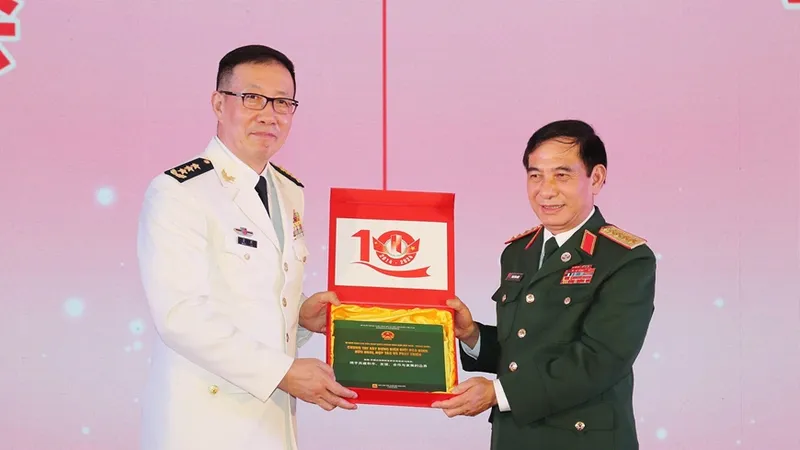 Bộ trưởng Phan Văn Giang tặng Bộ trưởng Đổng Quân cuốn sách ảnh “10 năm Giao lưu hữu nghị quốc phòng biên giới Việt Nam-Trung Quốc: Chung tay xây dựng biên giới hòa bình, hữu nghị, hợp tác và phát triển” do Báo Quân đội nhân dân biên soạn. Ảnh: Báo QĐND