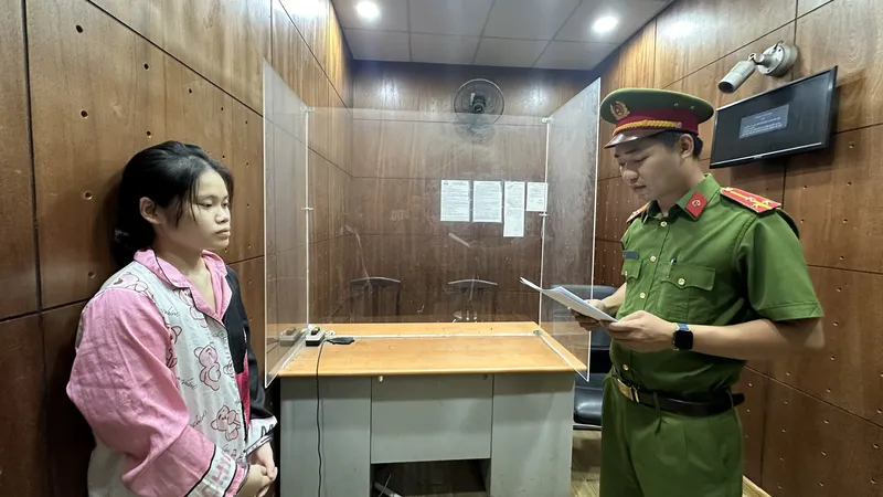 Công an tống đạt quyết định khởi tố đối tượng Phạm Huỳnh Nhật Vi. Ảnh: CHÍ THẠCH