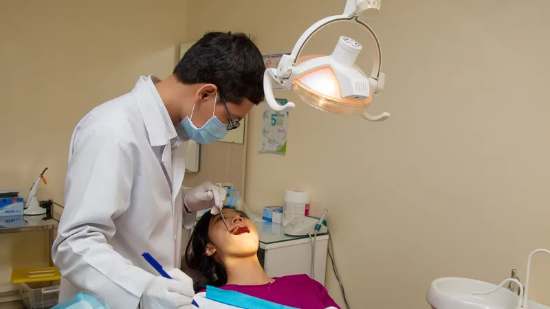 Bác sĩ nha khoa đang kiểm tra răng miệng cho một người bệnh. Ảnh: HOÀNG HÙNG