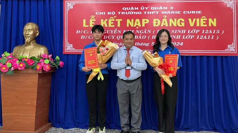 Thầy Nguyễn Vân Yên, Bí thư Chi bộ, Hiệu trưởng Trường THPT Marie Curie trao quyết định kết nạp Đảng cho em Lê Nguyễn Kim Ngân và Lê Duy Quốc Bảo