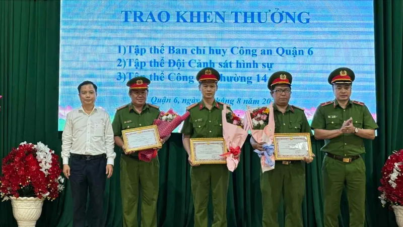 Thiếu tướng Mai Hoàng, Phó Giám đốc Công an TPHCM cùng Bí thư Quận ủy quận 6 Ma Xuân Việt trao giấy khen và hoa cho các đơn vị phá án
