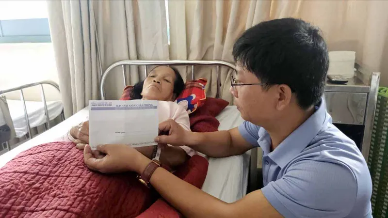 Phóng viên Báo SGGP trao 28 triệu đồng bạn đọc giúp bà Hường đang điều trị tại Bệnh viện Trung ương Huế cơ sở 2 