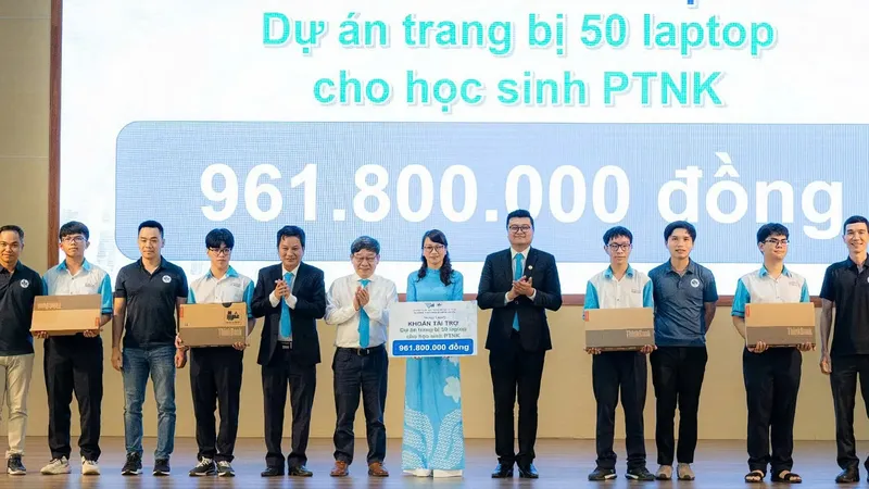 Thầy Nguyễn Thanh Hùng (áo sơ mi trắng) và một số cựu học sinh trao tặng laptop cho Trường Phổ thông Năng khiếu. Ảnh: V.H.