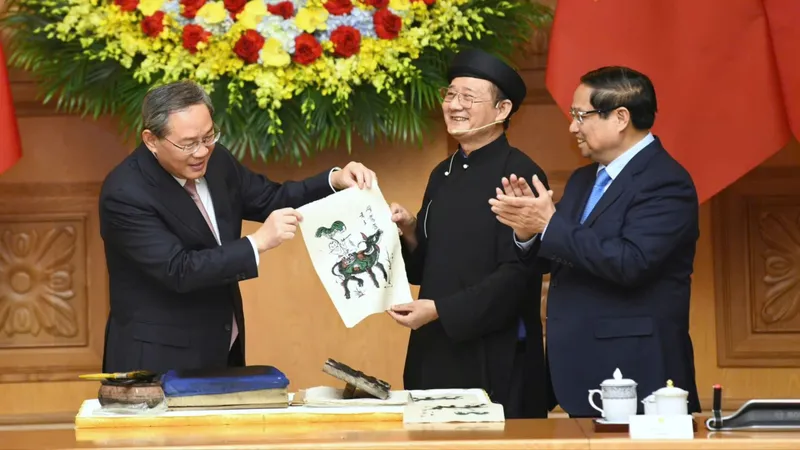 Thủ tướng Phạm Minh Chính và Thủ tướng Trung Quốc Lý Cường trải nghiệm làm tranh dân gian Đông Hồ, tối 13-10. Ảnh: VIẾT CHUNG