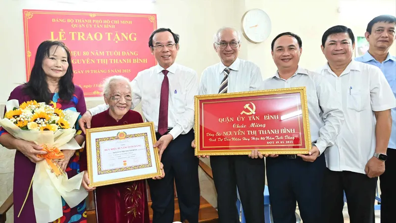Bí thư Thành ủy TPHCM Nguyễn Văn Nên trao Huy hiệu 80 năm tuổi Đảng đến đồng chí Nguyễn Thị Thanh Bình. Ảnh: VIỆT DŨNG