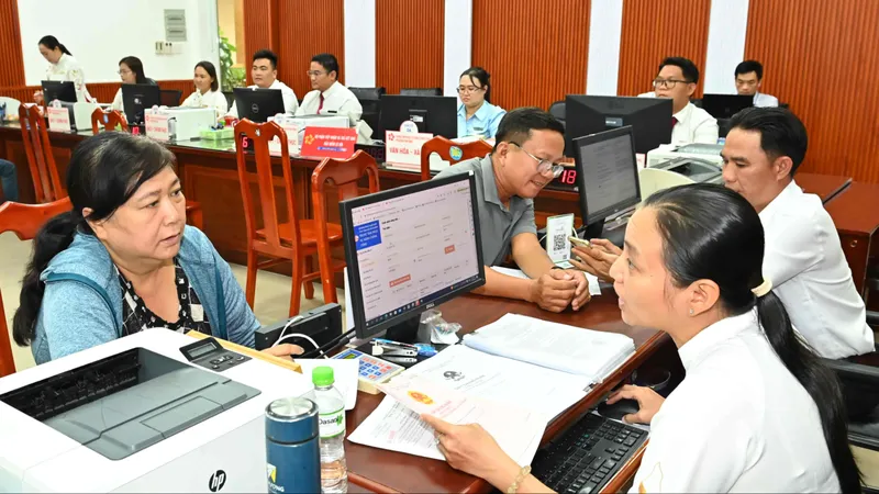 Hướng dẫn người dân làm thủ tục hành chính tại Trung tâm dịch vụ hành chính công phường Tam Bình, TPHCM. Ảnh: VIỆT DŨNG