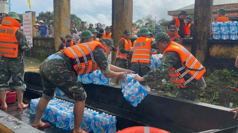 Cán bộ, chiến sĩ Quân khu 5 đưa nhu yếu phẩm đến người dân vùng ngập sâu tại xã Đại Lộc (TP Đà Nẵng). Ảnh: XUÂN QUỲNH