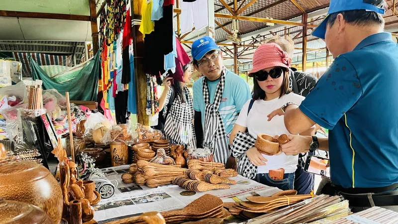 Du khách tìm hiểu về các sản phẩm làm từ dừa. Ảnh: GIA HÂN
