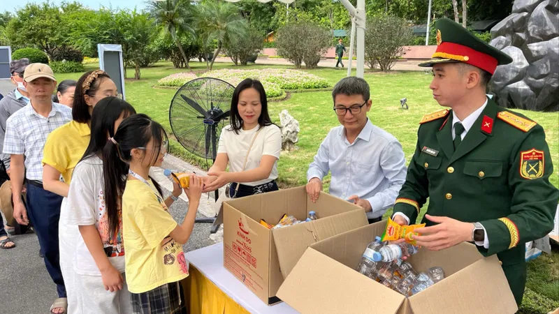 Tặng những phần quà nhỏ cho người dân và du khách viếng Bác trong ngày 30-4. Ảnh LAN HƯƠNG