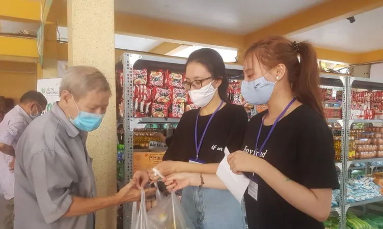 Các tình nguyện viên chọn hàng theo phiếu và trao tận tay cho người đi mua hàng