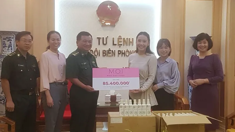 Đại diện Công ty Mỹ phẩm thương hiệu Việt M.O.I Cosmetics trao bảng tượng trưng số tiền tặng Bộ đội biên phòng