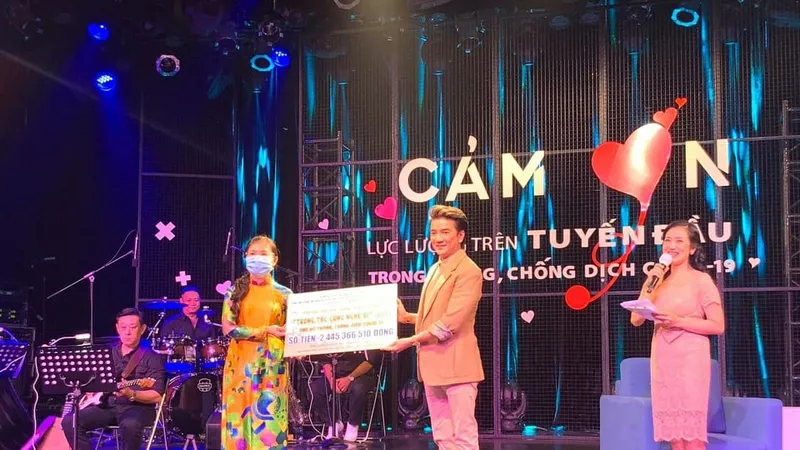 Ca sĩ Đàm Vĩnh Hưng (phải) trao số tiền hơn 2 tỷ đồng vận động đóng góp từ chương trình "Tương tác cùng nghệ sĩ" ủng hộ phòng, chống dịch Covid-19