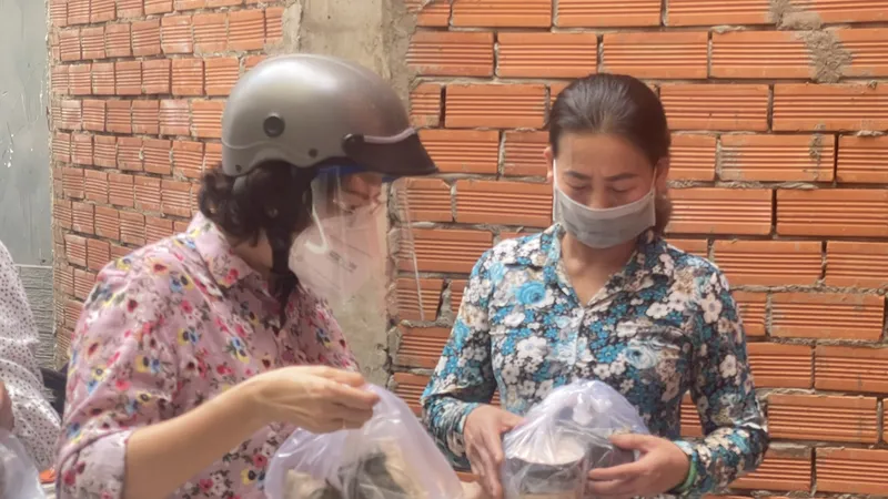 Chủ tịch Ủy ban MTTQ Việt Nam TPHCM Tô Thị Bích Châu trao tặng bánh chưng, chả lụa của đồng bào các dân tộc tỉnh Hà Giang đến các thợ hồ tại 1 công trình xây dựng trong hẻm 518 Lê Văn Sỹ