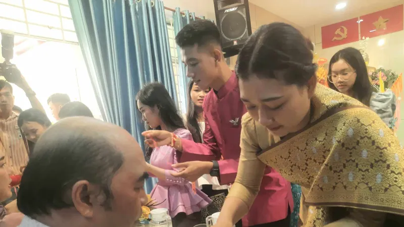 Du học sinh Lào buộc chỉ tay chúc mừng năm mới đến đại biểu dự họp mặt