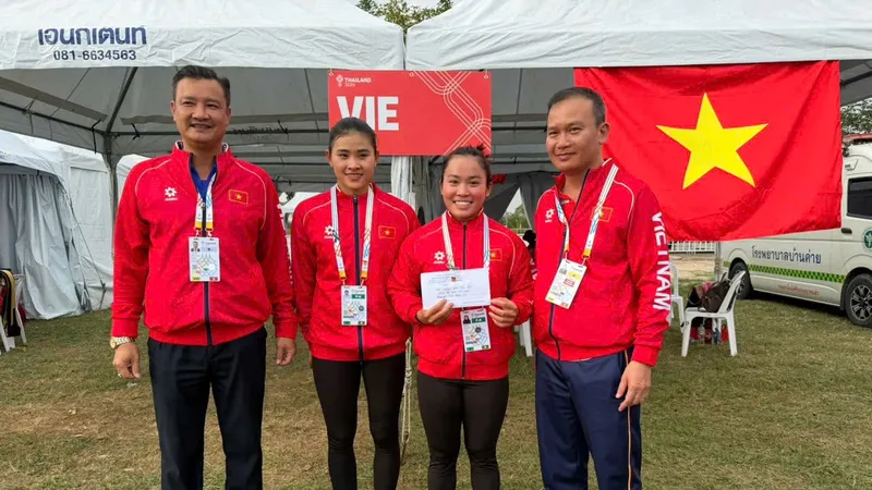 Trưởng đoàn thể thao Việt Nam tại SEA Games 33 Nguyễn Hồng Minh (bìa phải) trao thưởng nóng cho 2 tuyển thủ canoeing giành HCV đầu tiên. Ảnh: DŨNG PHƯƠNG