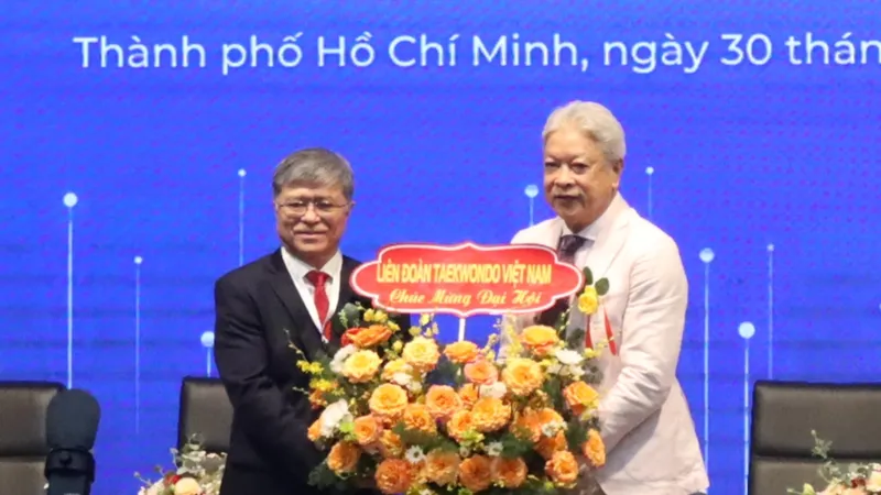 Ông Nguyễn Văn Hiếu (trái) nhận hoa chúc mừng từ Chủ tịch Liên đoàn Taekwondo Việt Nam Trương Ngọc Để. Ảnh: THANH TÙNG 