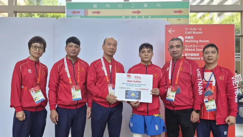 Đinh Văn Tâm (giữa) nhận thưởng từ đoàn thể thao Việt Nam sau tấm HCB ASIAD 20