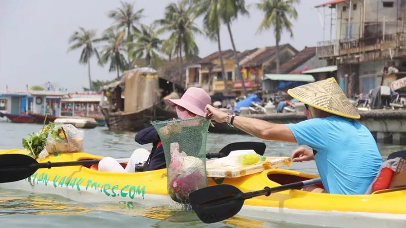 Hai du khách tham gia tour vớt rác trên sông Hoài (TP Hội An, tỉnh Quảng Nam)