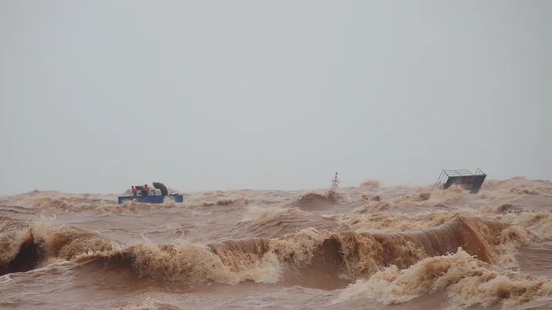 Các thuyền viên tàu Vietship 01 bám trên ống khói trên tàu, vào sáng 10-10. Ảnh: NGUYỄN HOÀNG
