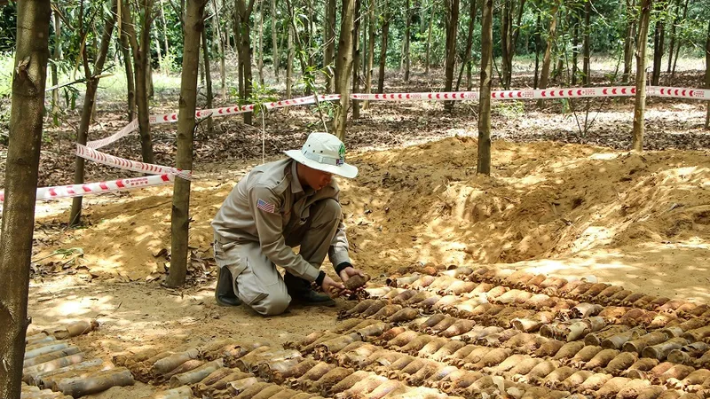 Đội trưởng đội rà phá hiện trường cẩn trọng di chuyển số đạn cối từ dưới hầm lên mặt đất.