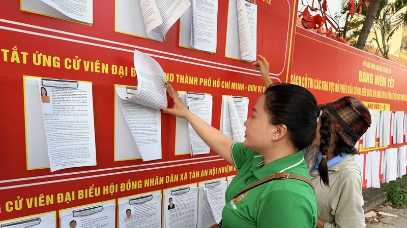 Cử tri xã Tân An Hội xem tiểu sử, chương trình hành động của các ứng cử viên đại biểu Quốc hội khóa XVI, đơn vị bầu cử số 12 tại UBND xã Tân An Hội. Ảnh: HOÀNG HÙNG)