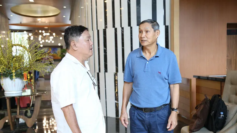 Ông Mai Đức Chung (phải) trò chuyện với thành viên Ban tổ chức Giải thưởng Quả bóng vàng Việt Nam 2023. ẢNH: TIÊU HẰNG 