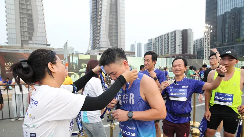 Các tình nguyện viên trao huy chương cho các runner khi về đích. ẢNH: DŨNG PHƯƠNG 